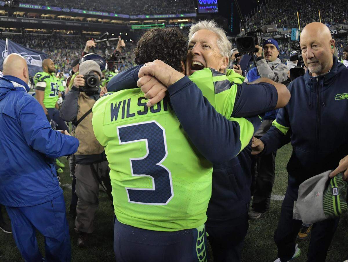 Seattle Seahawks quarterback Russell Wilson and head coach Pete Carroll embrace after the game against the Minnesota Vikings at CenturyLink Field. The Seahawks defeated the Vikings 37-30. 