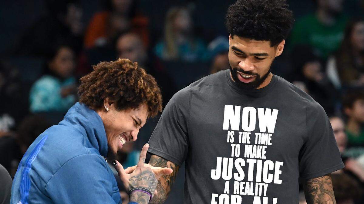 Injured Charlotte Hornets forward Kelly Oubre Jr., left, jokes with center Nick Richards, right, prior to the team’s game against the Boston Celtics at Spectrum Center in Charlotte, NC on Monday, January 16, 2023.