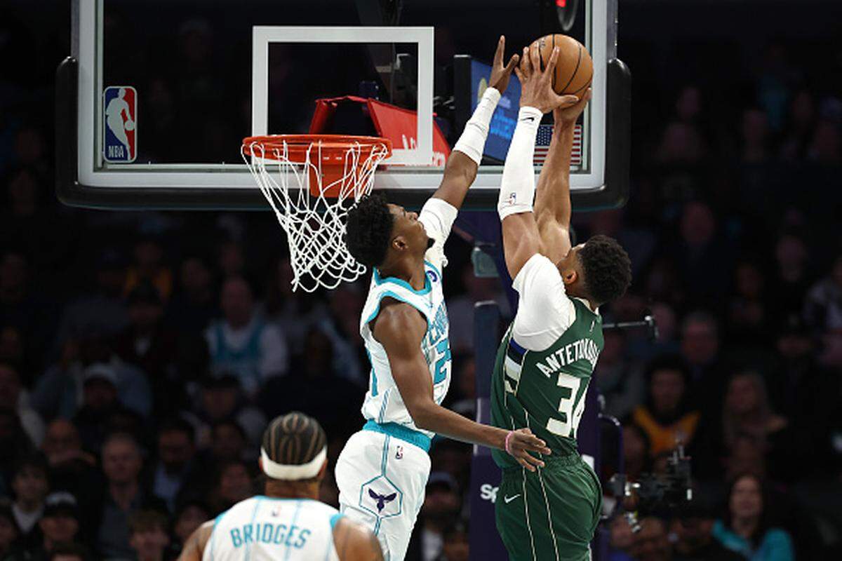 Brandon Miller of the Charlotte Hornets blocks a shot attempt from Giannis Antetokounmpo of the Milwaukee Bucks during the first quarter of the game at Spectrum Center.