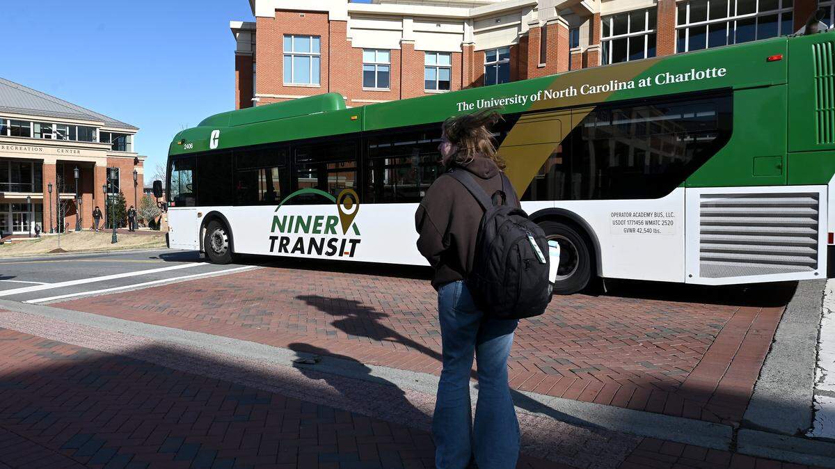 A UNC Charlotte student waits for a bus to pass before walking to the student union on Tuesday, March 17, 2026. Despite its size, density and growth, the University City area has not developed a good independent restaurant scene.