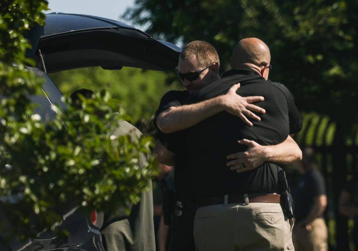 Officers embrace before the law enforcement processional for Officer William “Alden” Elliott, with the NC Department of Adult Corrections, leaves the Mecklenburg County Medical Examiner’s Office to Newton on Thursday, May 2, 2024. Four law officers died four wounded while serving a warrant in east Charlotte on Monday April 29, 2024.