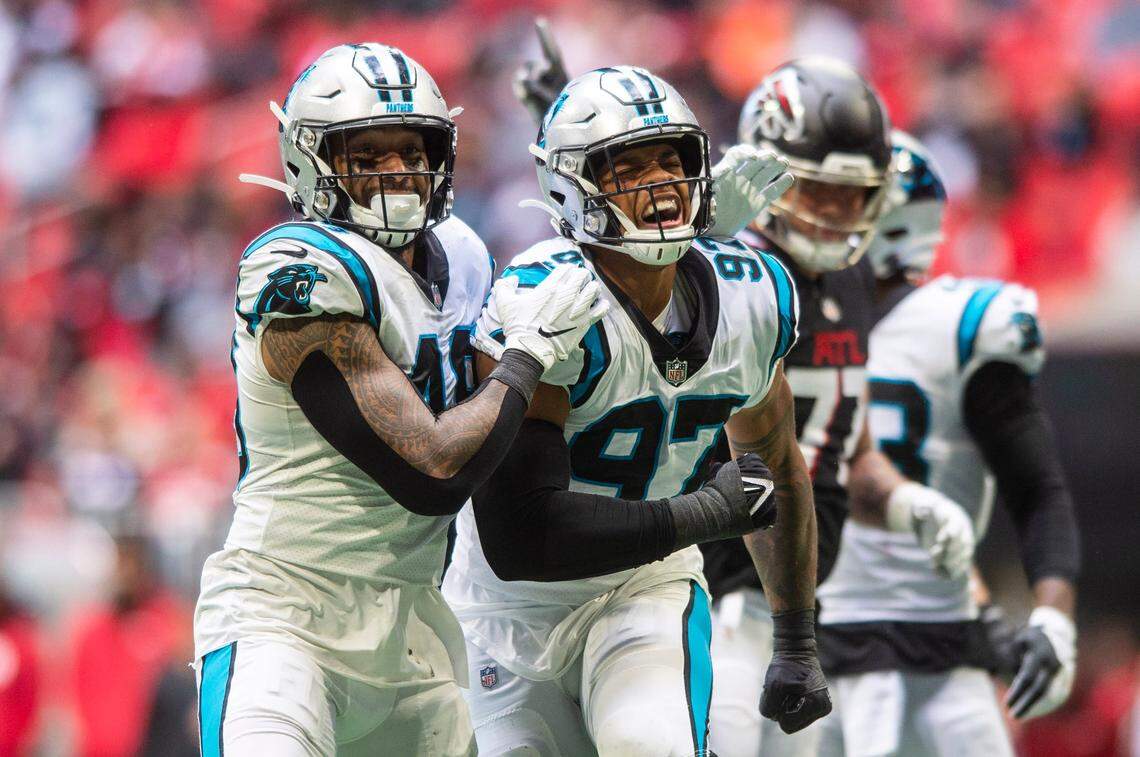 Panthers linebacker Frankie Luvu, left and defensive end Yetur Gross-Matos, center, celebrate after Gross-Matos sacks Falcons quarterback Matt Ryan during the game against the Falcons at Mercedes-Benz Stadium on Sunday, October 31, 2021 in Atlanta, GA.