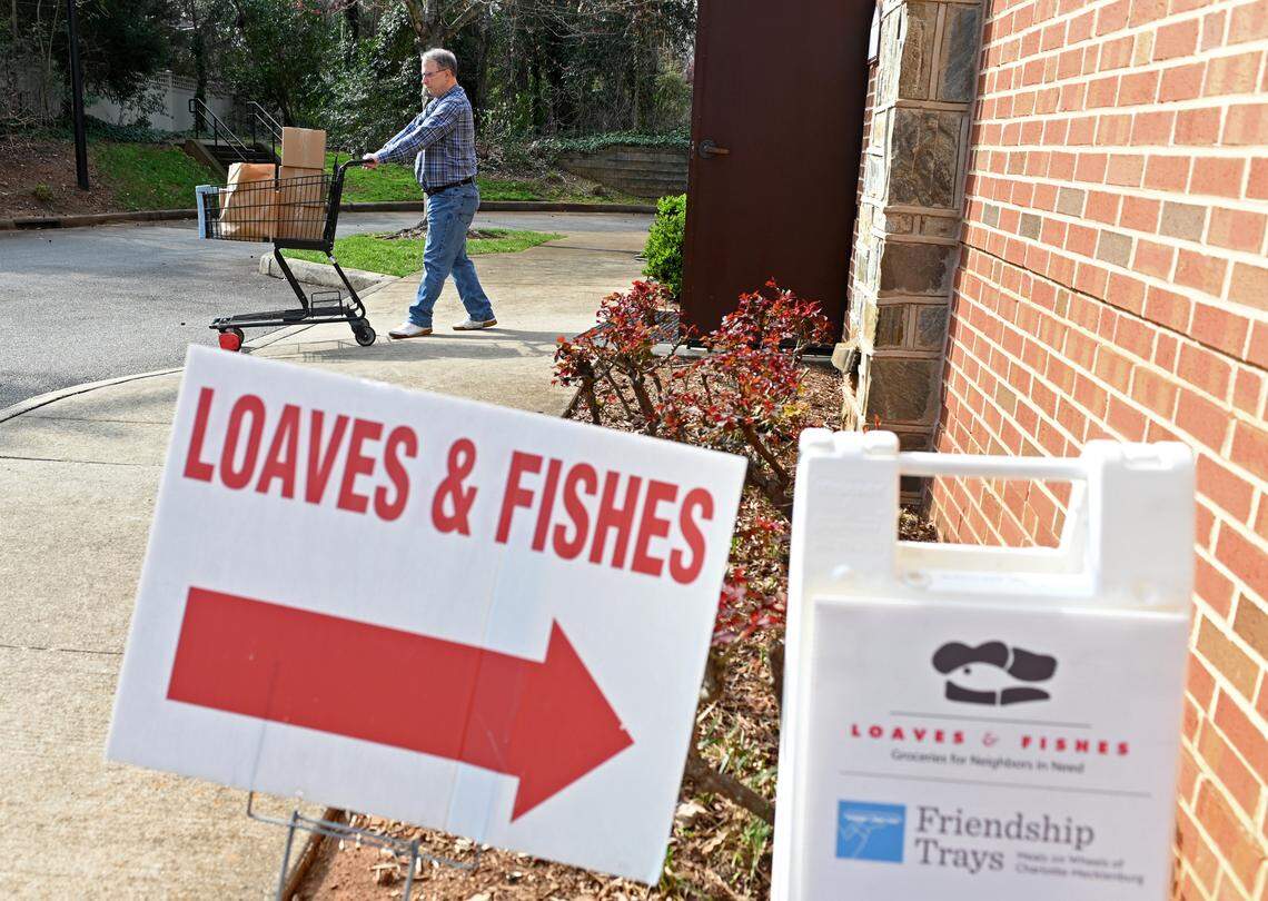 Loaves & Fishes volunteer Gil Gaffney uses a shopping cart to deliver groceries to a clients car on Monday, February 27, 2023 at Holy Comforter Episcopal Church in Charlotte, NC. Loaves & Fishes/Friendship Trays have seen an explosion in need and are bracing for the end of increased snap benefits on Tuesday, February 28, 2023.