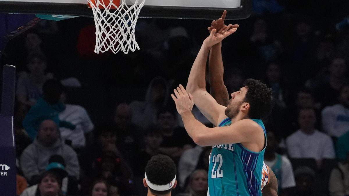 Mar 15, 2024; Charlotte, North Carolina, USA; Charlotte Hornets guard Vasa Micic (22) shoots over Phoenix Suns guard Devin Booker (1) during the second quarter at Spectrum Center.