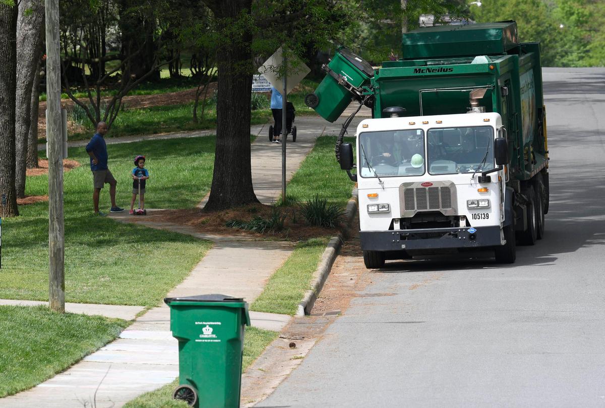 A recycling truck reaches out and empties a bin, as spectators watch, along Robinhood Road in Charlotte on Tuesday, April 7, 2020.Yes, yard waste pick up has been delayed but don’t put it in with your recyclables.