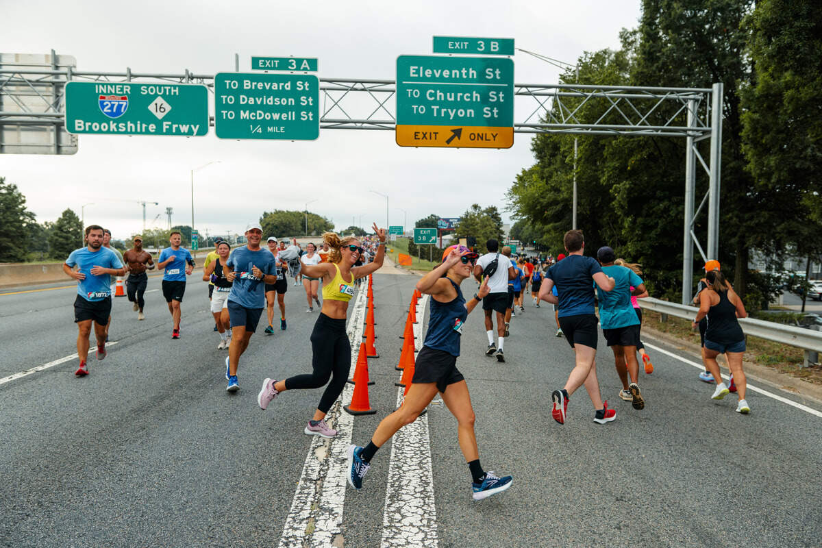 Runners make a turn at an exit on Interstate 277 in the 2022 Around the Crown 10K.