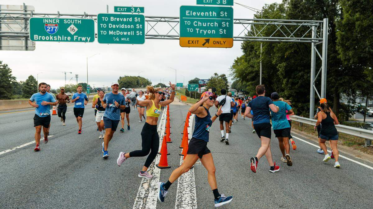 Runners make a turn at an exit on Interstate 277 in the 2022 Around the Crown 10K.