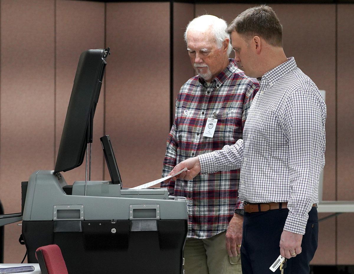 48th Precinct Official Ed King, left, assists voter Brian Soja, right, as he casts his ballot into the Tabulator after voting at Providence United Methodist Church on Tuesday, March 3, 2020. Voters at the precinct now vote using the new ExpressVote machine where they mark their ballots and cast them in the Tabulator. Precinct Chief Judge Jane Pasquini says that the machines are quick, quiet and everyone seems to like them.