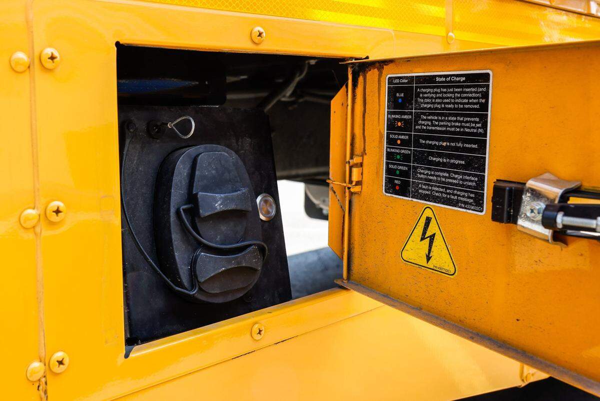 The electric school receives a charge through this port on the right side of the bus.