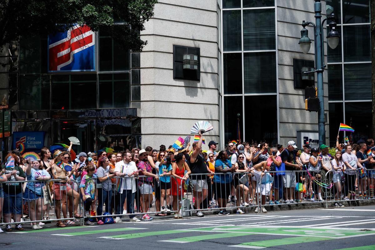 Parade attendees gather along the sides of the street, waving rainbow colored fans and flags during the Charlotte Pride Festival & Parade on Sunday, Aug. 18, 2024