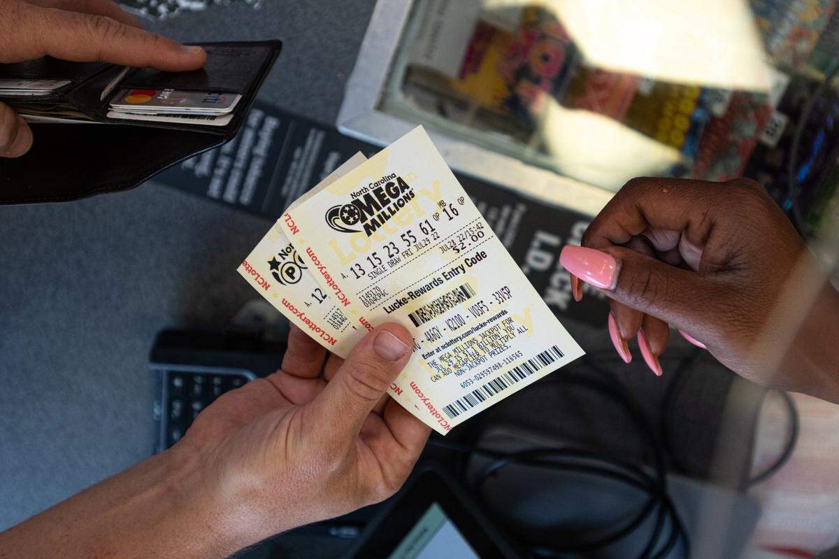 Alston Gore, 38, purchases a handful of Mega Millions lottery tickets at a gas station on Freedom Drive in Charlotte on Thursday, July 28, 2022.