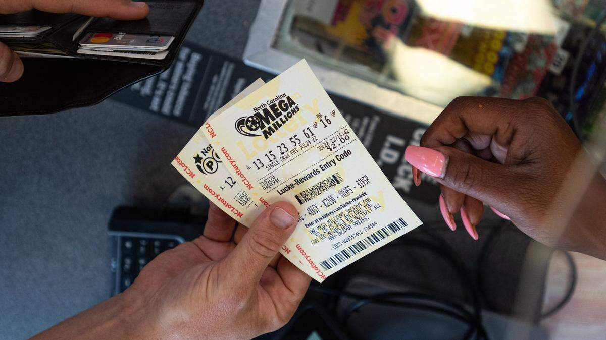 Alston Gore, 38, purchases a handful of Mega Millions lottery tickets at a gas station on Freedom Drive in Charlotte, N.C., Thursday, July 28, 2022. “Every time I stop for gas, I grab a lottery ticket,” Gore said. As of July 28, Mega Millions estimated their next jackpot at a whopping $1.1 billion.