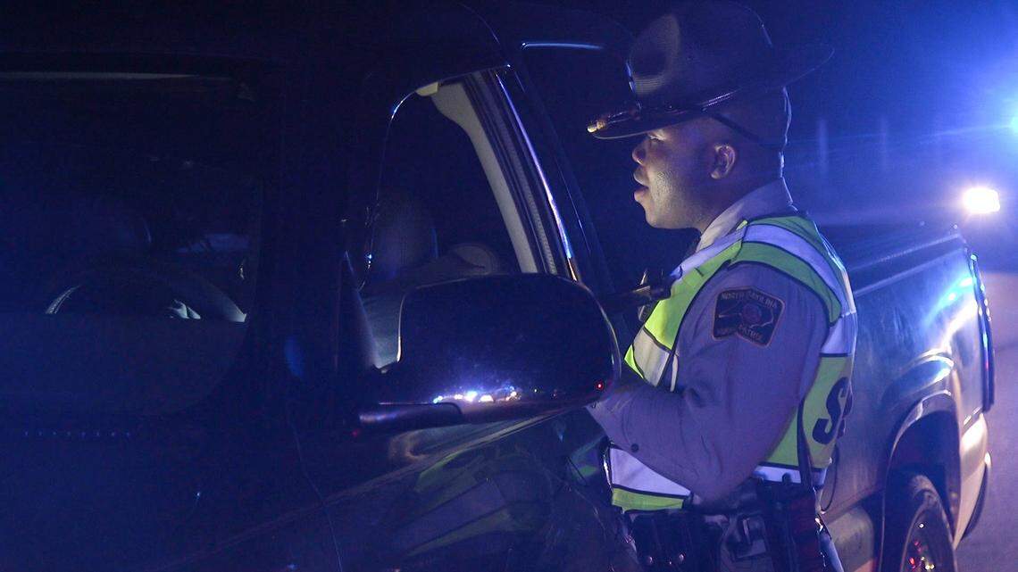 Trooper Charles Montgomery, with the N.C. Highway Patrol, questions a driver at a license checkpoint.