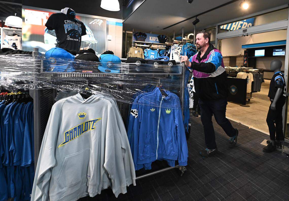 Dennis Soden, general manager of retail at Bank of America Stadium, rolls a display of Charlotte FC merchandise into the team store on Monday. Cews worked throughout Sunday and Monday to ready the stadium for the transformation from football venue to hosting Tuesday’s MLS playoff opener.