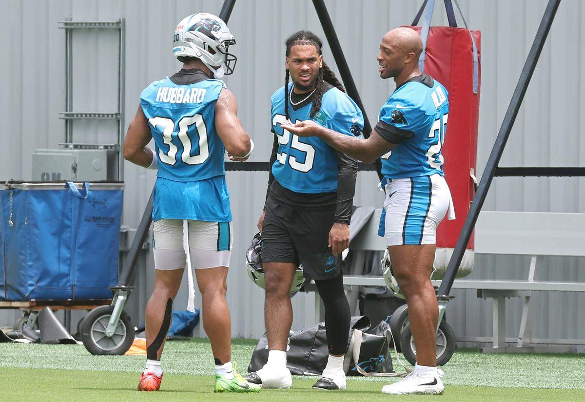 Carolina Panthers running backs Chuba Hubbard, left, Jonathon Brooks, center and AJ Dillon, right, talk during a break in the team's first open workout on Tuesday, May 26, 2026.