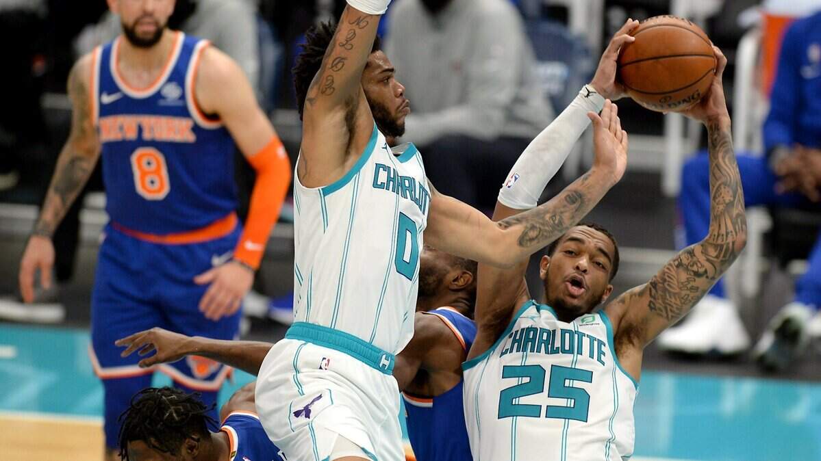 Charlotte Hornets forward P.J. Washington, right, secures a rebound during second half action against the New York Knicks on Monday, January 11, 2021 at Spectrum Center in Charlotte, NC. The Hornets defeated the Knicks 109-88.