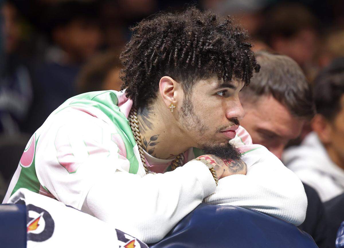 Injured Charlotte Hornets guard LaMelo Ball sits behind the team bench during action against the Denver Nuggets at Spectrum Center in Charlotte, North Carolina, on Dec. 7, 2025.