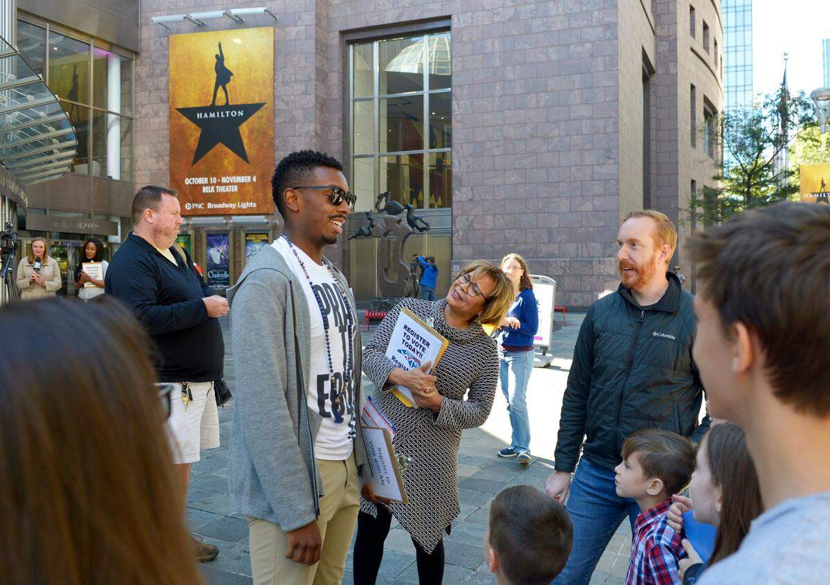 Tyler McKenzie, left, an ensemble member of “Hamilton” who went to Central Academy of Technology and Arts in Monroe and Weddington High School and now lives in Brooklyn NY, and Charlotte Mayor Vi Lyles greet people during a voter registration drive in front of the Belk Theater Friday. Some members of the cast of the Broadway smash “Hamilton,” and Mayor Vi Lyles held a voter registration drive in front of Belk Theater on the final day to register to vote in NC. Blumenthal Performing Arts teamed up with the non-partisan voter education organization You Can Vote to help register and educate voters. Hamilton opened Wednesday and will be in town through Nov. 4.