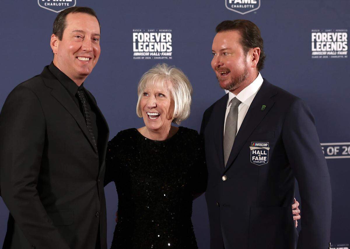 NASCAR driver Kyle Busch (left), mother Gaye Busch and former NASCAR driver and 2026 Hall of Fame inductee Kurt Busch pose for photographs on the red carpet at the NASCAR Hall of Fame on Jan. 23, 2026. 