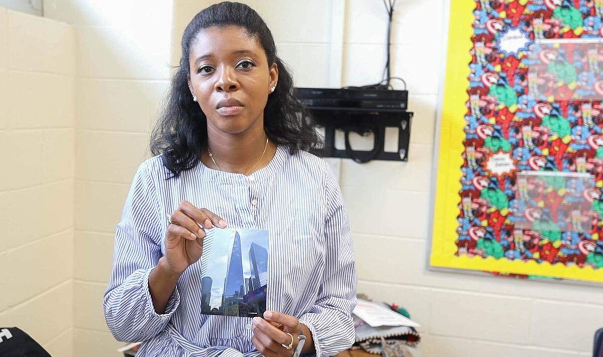 Kiara Eden holds up a photo of One World Trade Center, which was built 2006-2014 on the site of the original twin towers.