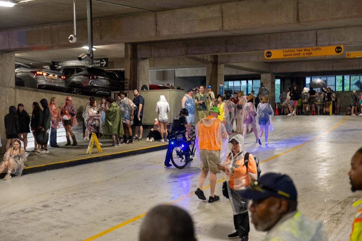 Fans seeking shelter from lightning in a parking deck during Lovin’ Life Music Fest.