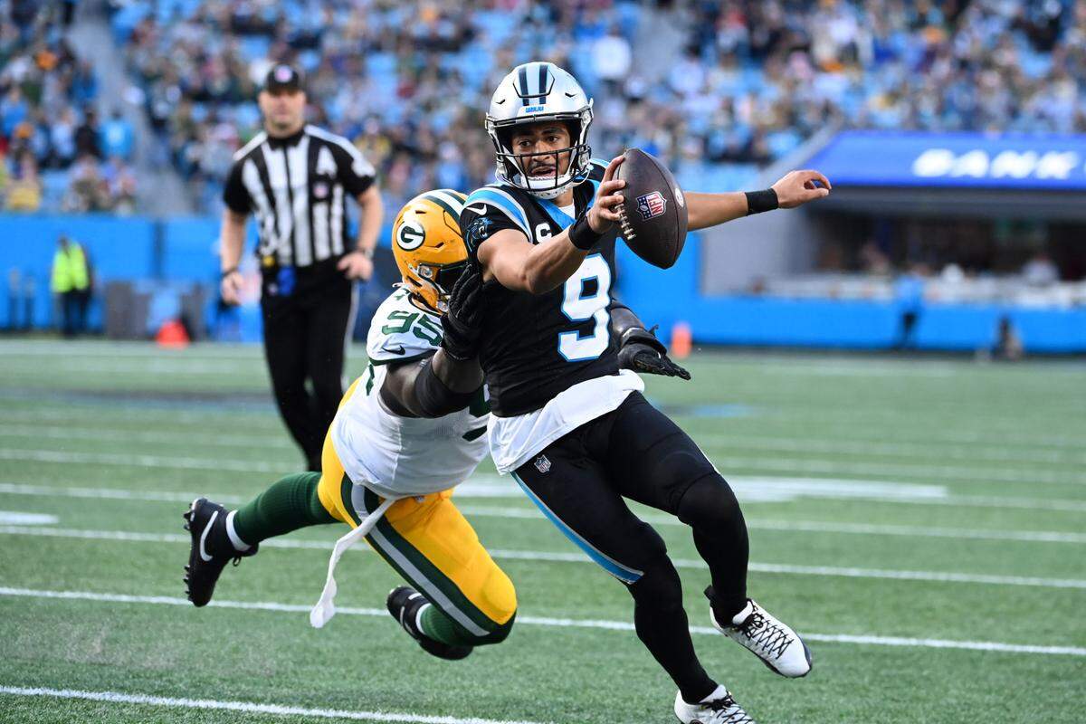 Dec 24, 2023; Charlotte, North Carolina, USA; Carolina Panthers quarterback Bryce Young (9) scrambles as Green Bay Packers defensive tackle Devonte Wyatt (95) defends in the fourth quarter at Bank of America Stadium. Mandatory Credit: Bob Donnan-USA TODAY Sports
