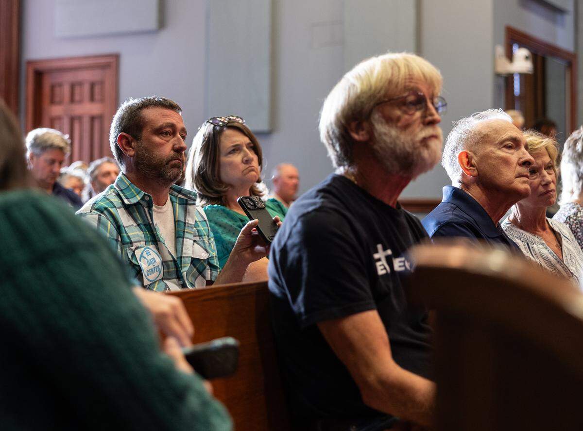 Protesters and supporters listen during a hearing by the Statesville Planning Board on a rezoning request for the proposed Stamey Farms data center in Statesville, N.C., on Tuesday, August 26, 2025.