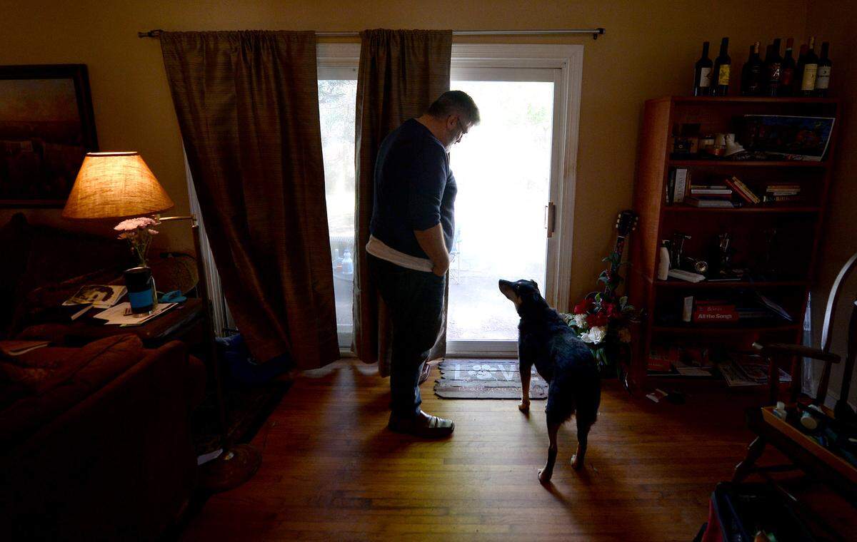 Joe Kuhlmann and his dog Wolfgang, at the sliding glass door in his house that was jimmied open on Jan. 26.