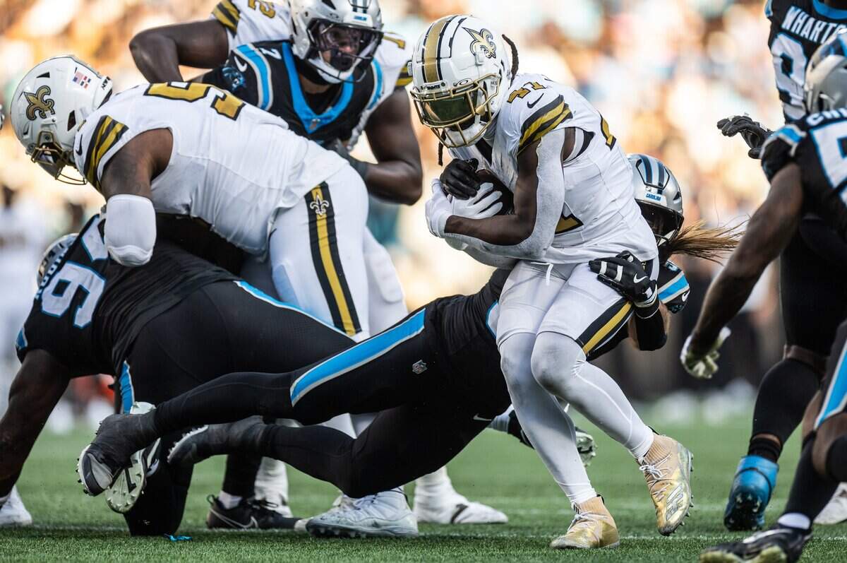 New Orleans Saints running back Alvin Kamara, right, is tackled by Carolina Panthers linebacker Christian Rozeboom on Sunday at Bank of America Stadium.