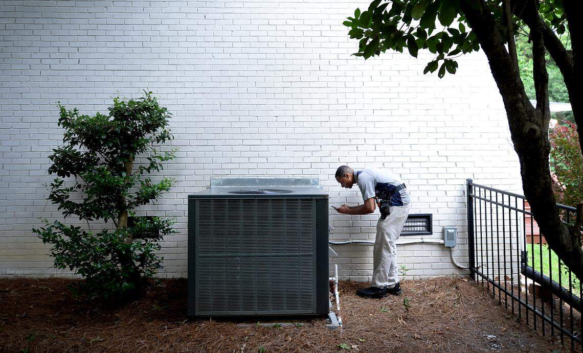 Weatherizing homes, including updating heat and air systems and adding insulation, is widely seen as a tool to address climate change by cutting energy demand. Home inspector Michael Taylor, of Home Inspection Carolina, checks an HVAC unit outside a home in south Charlotte on Friday, July 9, 2021.