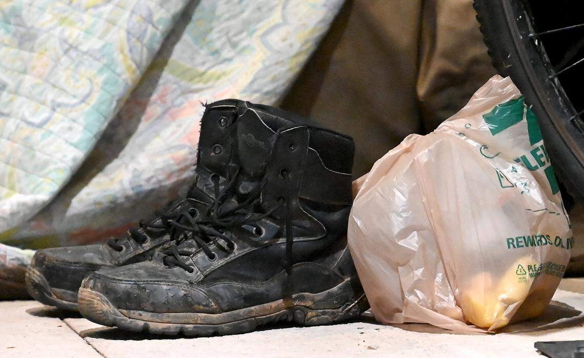 Boots and groceries sit next to a homeless’s bedding along Church St. in uptown Charlotte, NC., on Thursday, January 26, 2023. Point-in-Time Count Volunteers aim to get an accurate statistic of how many people in Charlotte are homeless, live in shelters or tents or cars, or otherwise have unstable housing arrangements.
