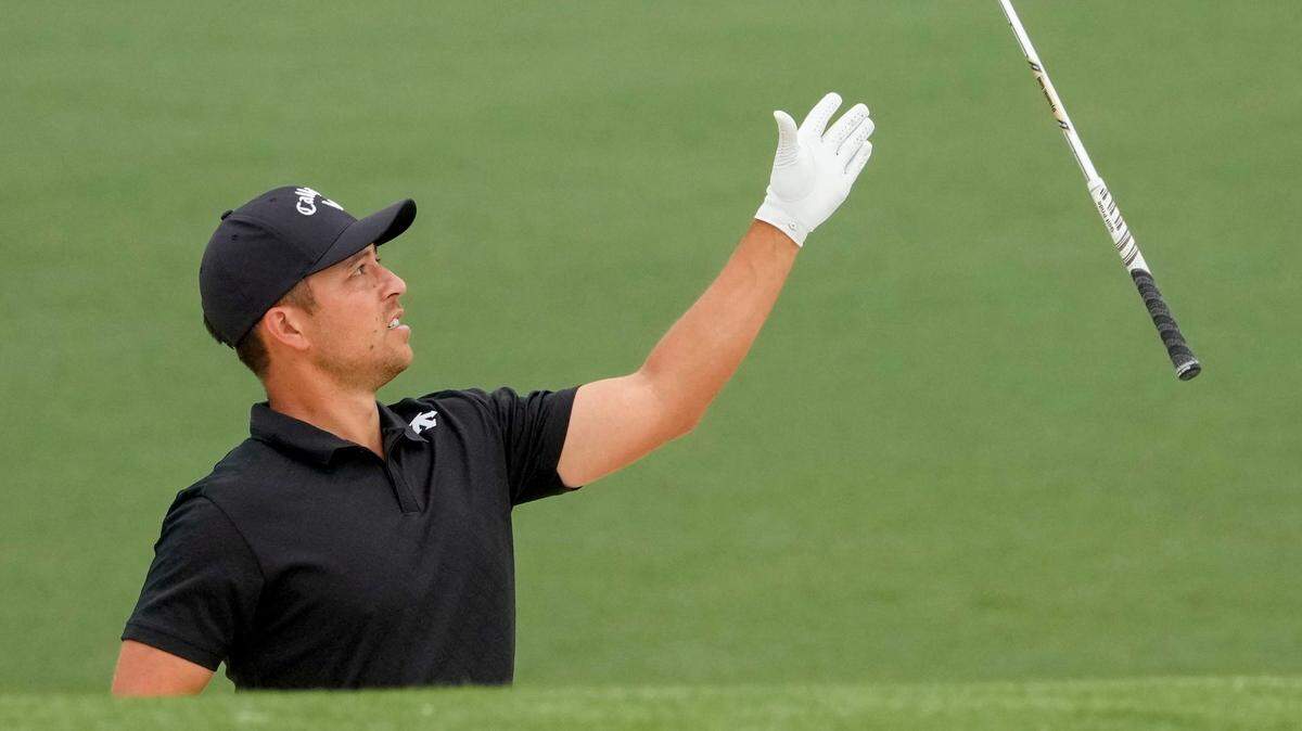 Xander Schauffele catches a club tossed to him by his caddie while standing in a bunker on No. 2 during a practice round for the Masters Tournament golf tournament in 2024.