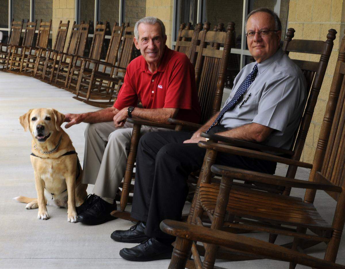 9/15/2009 - Catawba Valley Behavioral Healthcare director John Waters (right) and NASCAR legend Ned Jarrett (left) with Ria, a service dog at Life Skills near the offices of Catawba Valley Behavioral Healthcare in Hickory.  The non-profit Behavioral Healthcare agency must move out of it's current offices and is looking for a new building, and having to deal with deep budget cuts.  Ned Jarrett has agreed to chair a fund drive that hopes to raise $500,000.00 this Fall.      JEFF WILLHELM - jwillhelm@charlotteobserver.com
