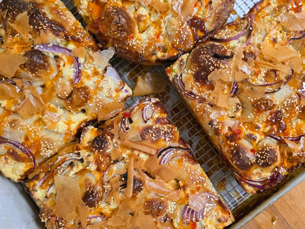 A variety of focaccia loaves are served daily at Virtuoso Breadworks, including its salt and pepper focaccia and rotating creations including cheese rangoon focaccia, topped with phyllo and togarashi.