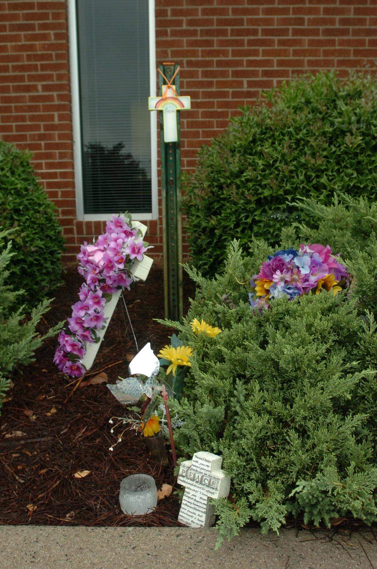 A memorial of flowers,crosses and candles left by the public outside the Sun Drop Bottling Co. two months after Donna Barnhardt and Darrell Noles were killed there on June 13, 2008.