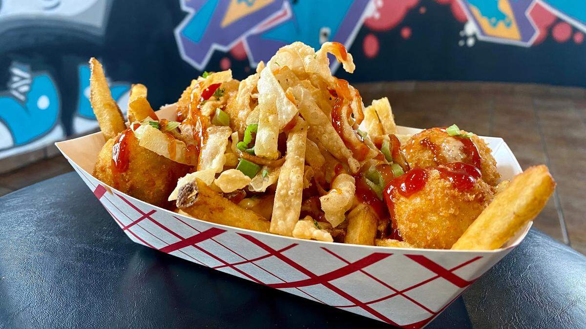 What the Fries’ Crab Rangoon Fries are topped with scratch-made crab rangoon fritters, Yum Yum Sauce, scallions, sweet and sour sauce and crispy wontons ($18).