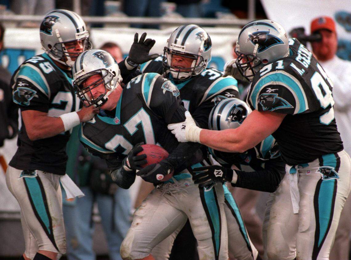 Teammates mob Panthers safety Chad Cota (37) after he intercepted a Pittsburgh pass in the end zone to seal a Carolina win in 1996 that clinched the team’s first division title.