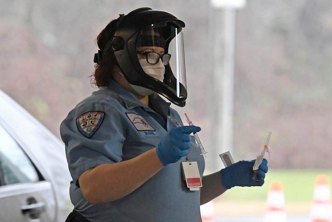A Gaston County Emergency Medical Services (GEMS) paramedic carries syringes at a COVID vaccination clinic during Gaston County Department of Health and Human Services sponsored Phase 1B vaccine clinic at the Gastonia FarmerÕs Market on Friday, January 8, 2021.