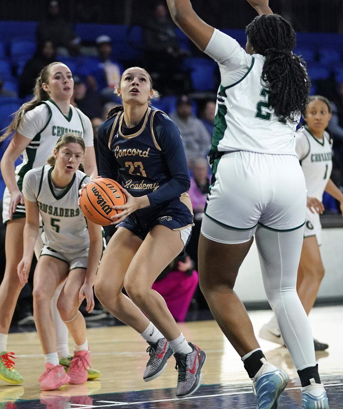 Concord Academy's Justice Alexander, center, goes between Grace Christian's Cooper Cox, left, and Kyndoll English for a layup during the first half of their N.C. Independent Schools Athletic Association 3A girls state championship game Friday, Feb. 27, 2026, in Greensboro, N.C. (Credit: Bill Kiser/Special to the Charlotte Observer)