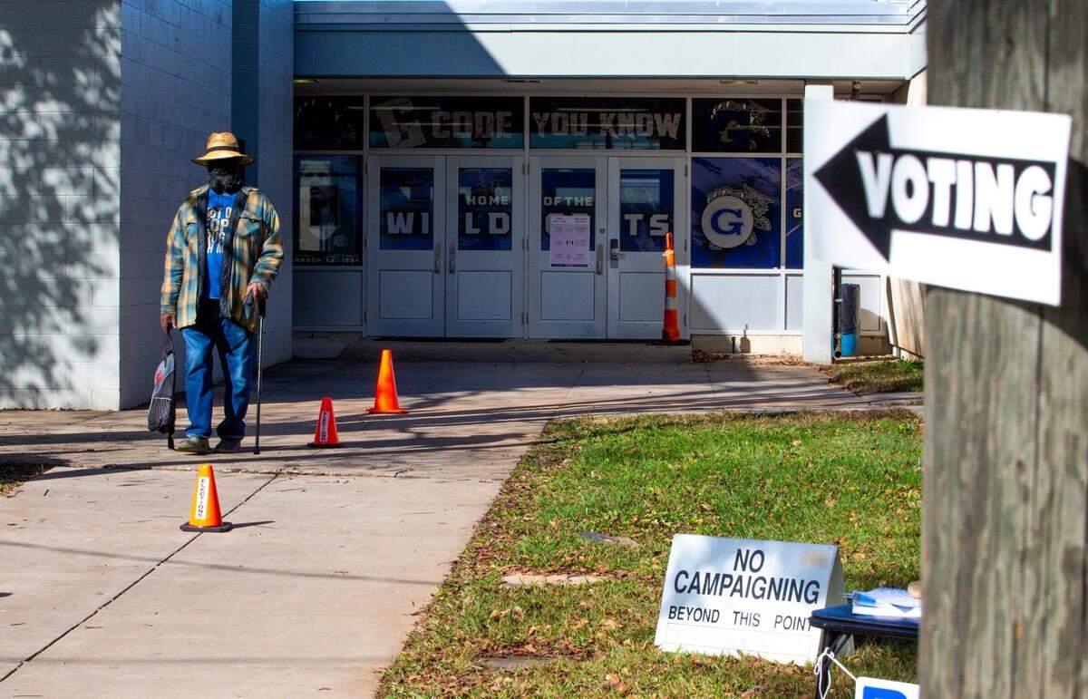 A voter walks out of Garinger High School in Charlotte, NC on Tuesday, November 3, 2020. There were no lines at the high school on Tuesday and voters were able to easily come and go.