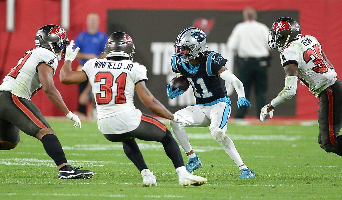 Carolina Panthers wide receiver Robby Anderson, center, looks to find running room following a pass reception during third quarter action against the Tampa Bay Buccaneers at Raymond James Stadium in Tampa, Fl. on Sunday, January 9, 2022. The Panthers lost to the Buccaneers 41-17.