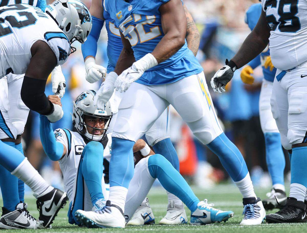 Panthers quarterback Bryce Young gets help standing up after being sacked during Sunday’s game against the Los Angeles Chargers at Bank of America Stadium.