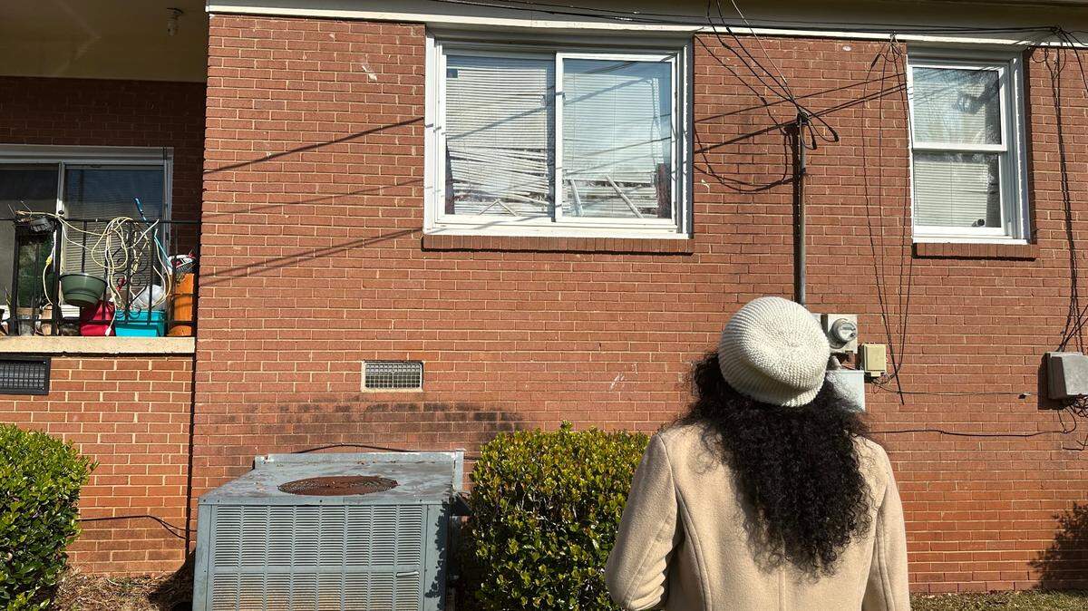 A west Charlotte woman stares at the window where a burglar climbed inside her home on Dec. 17. It was at least the second break-in in the last couple of weeks, but she’s worried there’s been others.