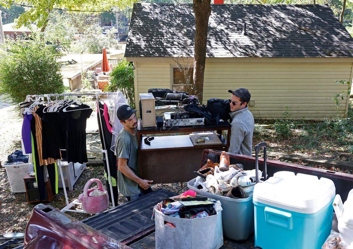 As flood water from the Catawba River continues to rise, Jesse Riggins, left and brother Lucas Riggins, right, carry household items from Jesse Riggins’ home on Riverside Drive to a pickup truck on Saturday, September 28, 2024.