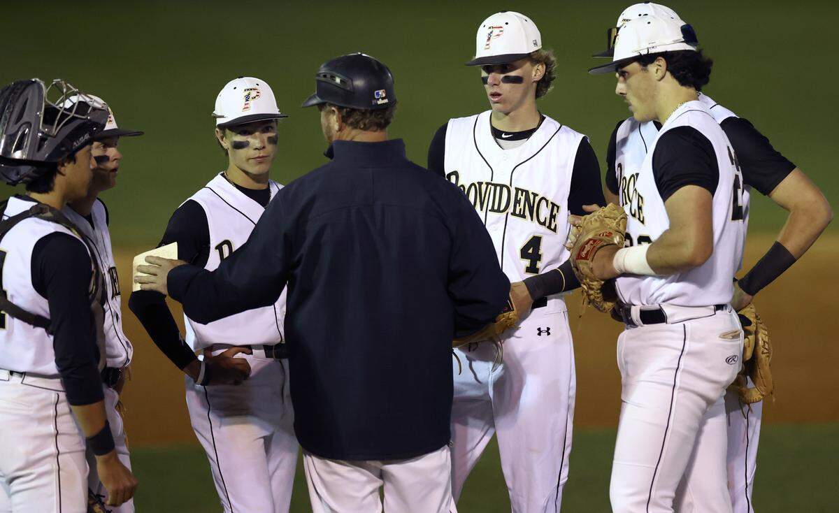 Providence Panthers pitcher Brady Thompson, center/right, listens to head coach Danny Hignight, back to camera, during a visit to the mound on Friday, April 12, 2024. Providence hosted Hopewell in prep baseball action.