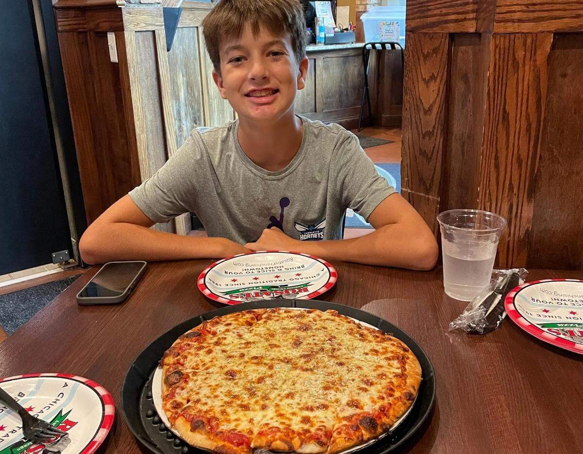 Tristan Graziano with Rosati’s thin crust pizza.