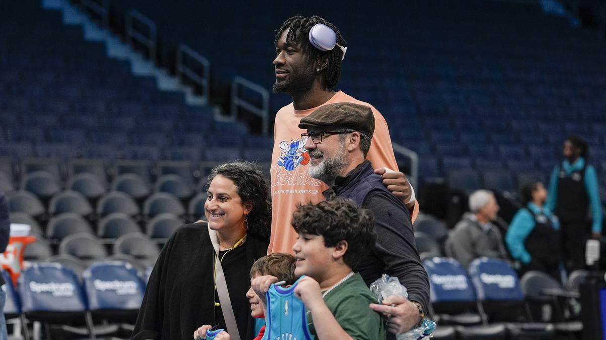 Mark Williams poses for a family photo during pregame warm ups against the Milwaukee Bucks at Spectrum Center.