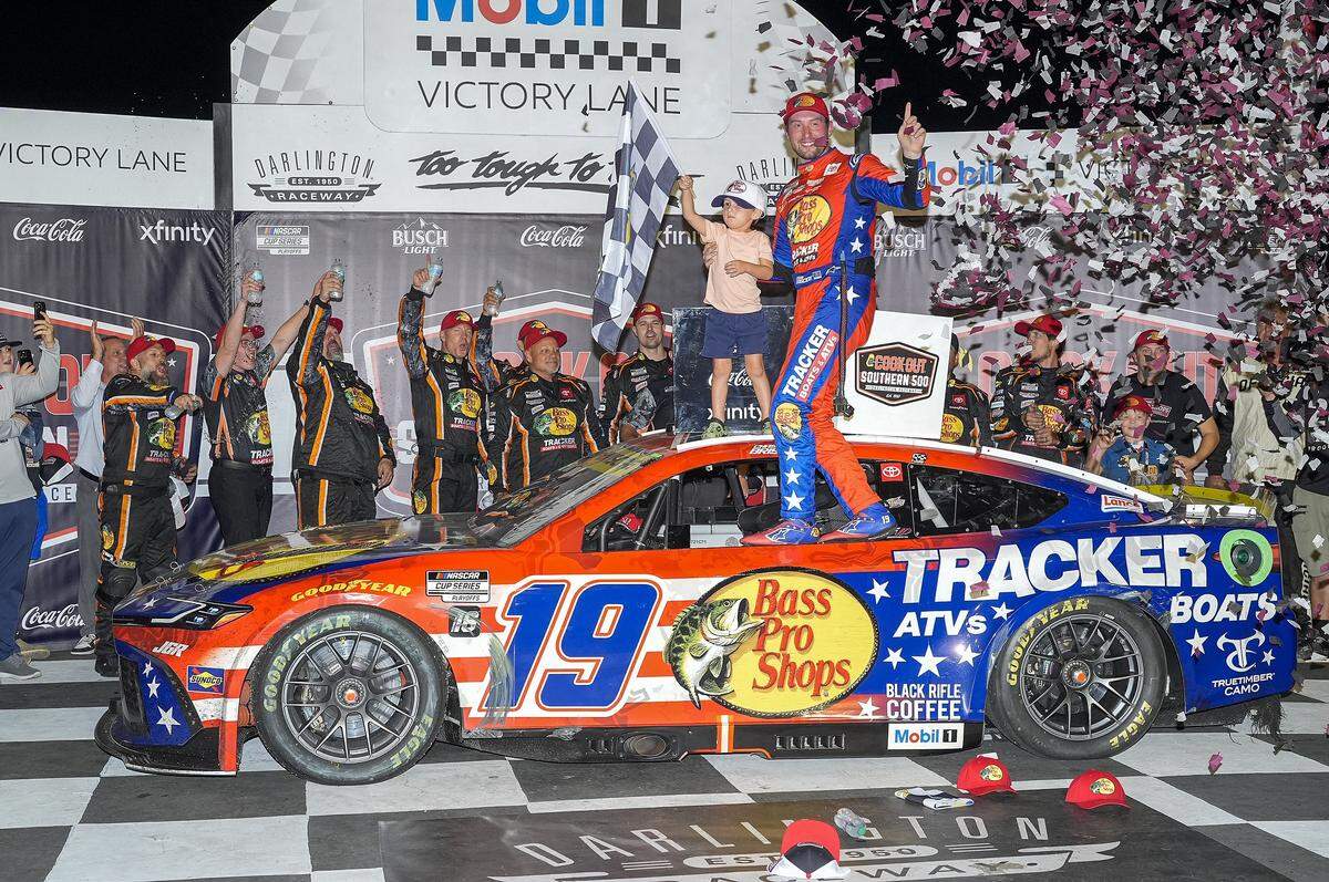 Aug 31, 2025; Darlington, South Carolina, USA; NASCAR Cup Series driver Chase Briscoe (19) and his son Brooks celebrates his win at the Cookouts Southern 500 at Darlington Raceway.