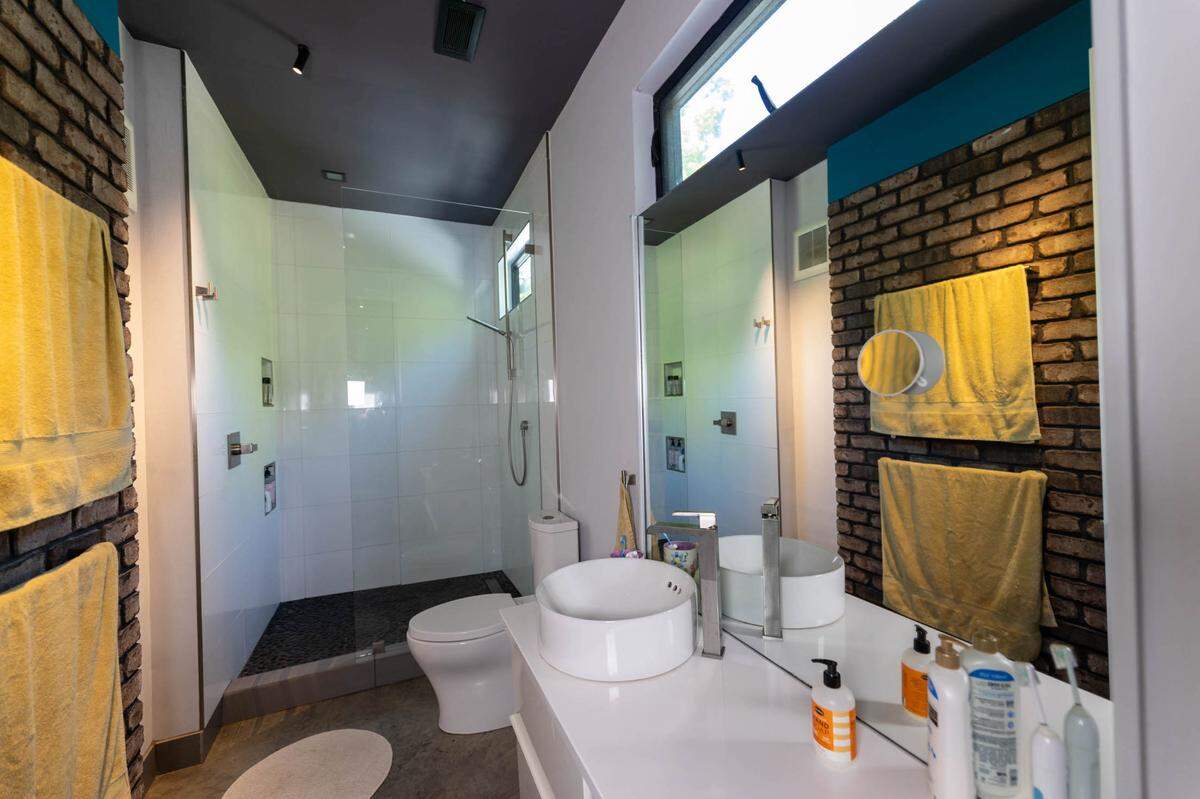 The brick wall outside makes its way into the second-story bathroom.