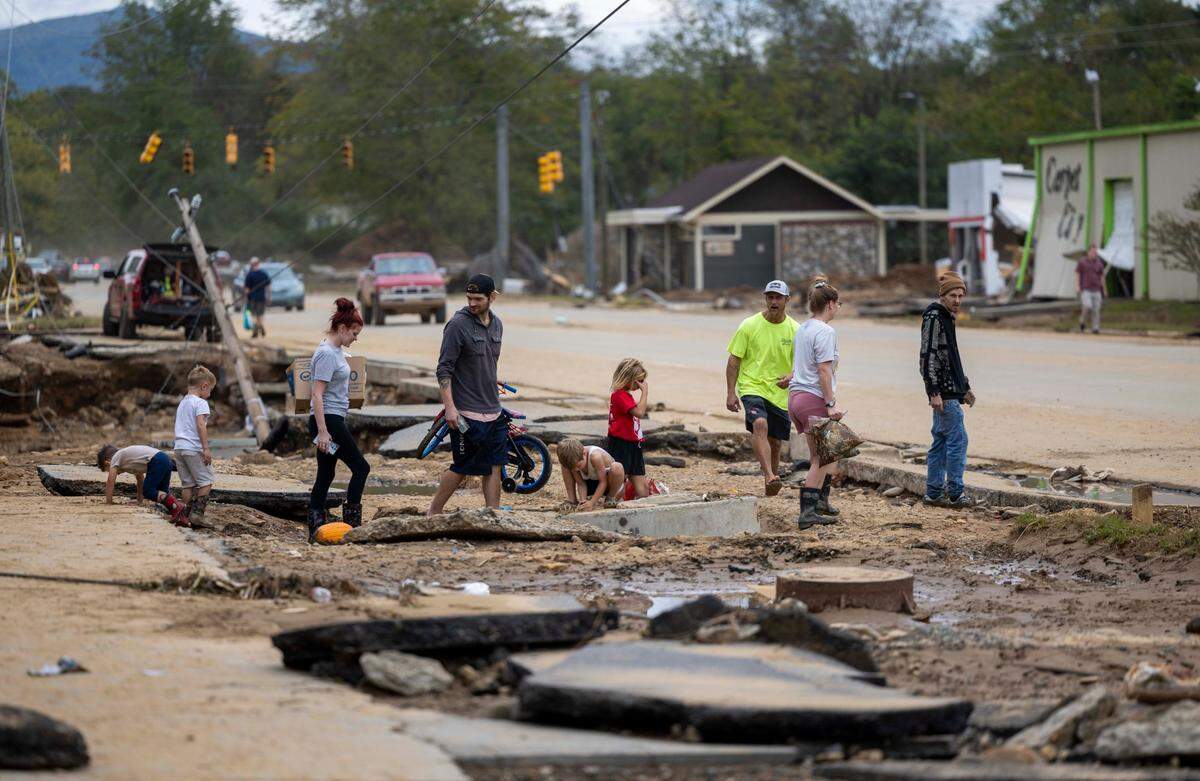 Swannanoa residents walk through devastating flood damage from the Swannanoa River on Sunday, Sept. 29, 2024. The remnants of Hurricane Helene caused widespread flooding, downed trees, and power outages in western North Carolina.